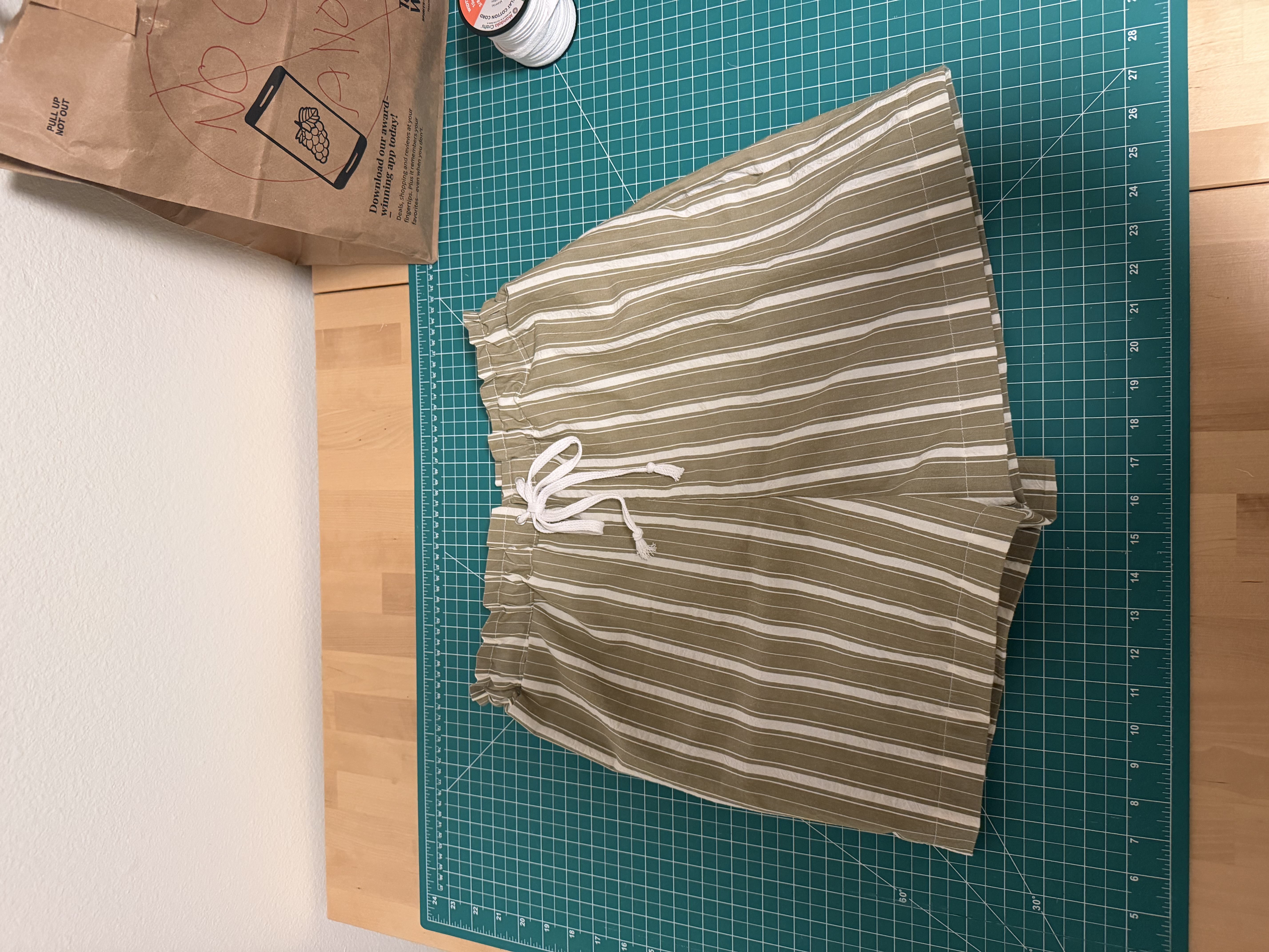 The finished striped shorts laid flat with the drawstring tied